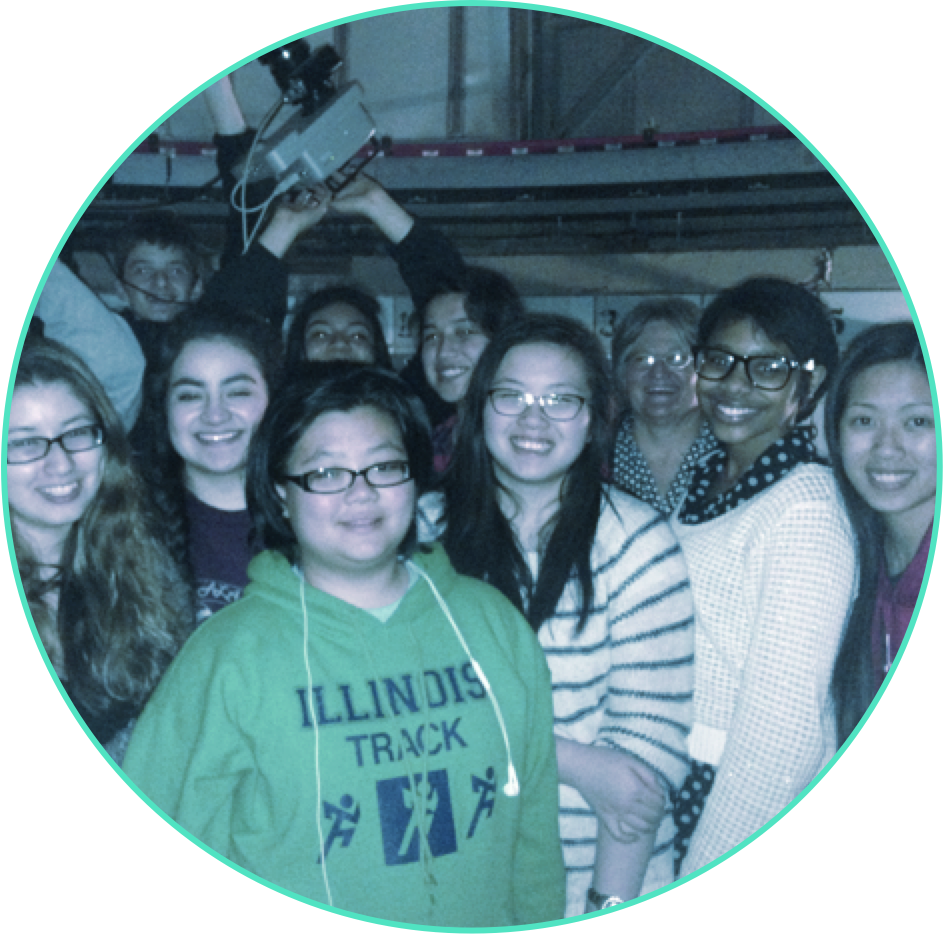 A group of high-school-age students assembled for a group picture inside the dome of an observatory.